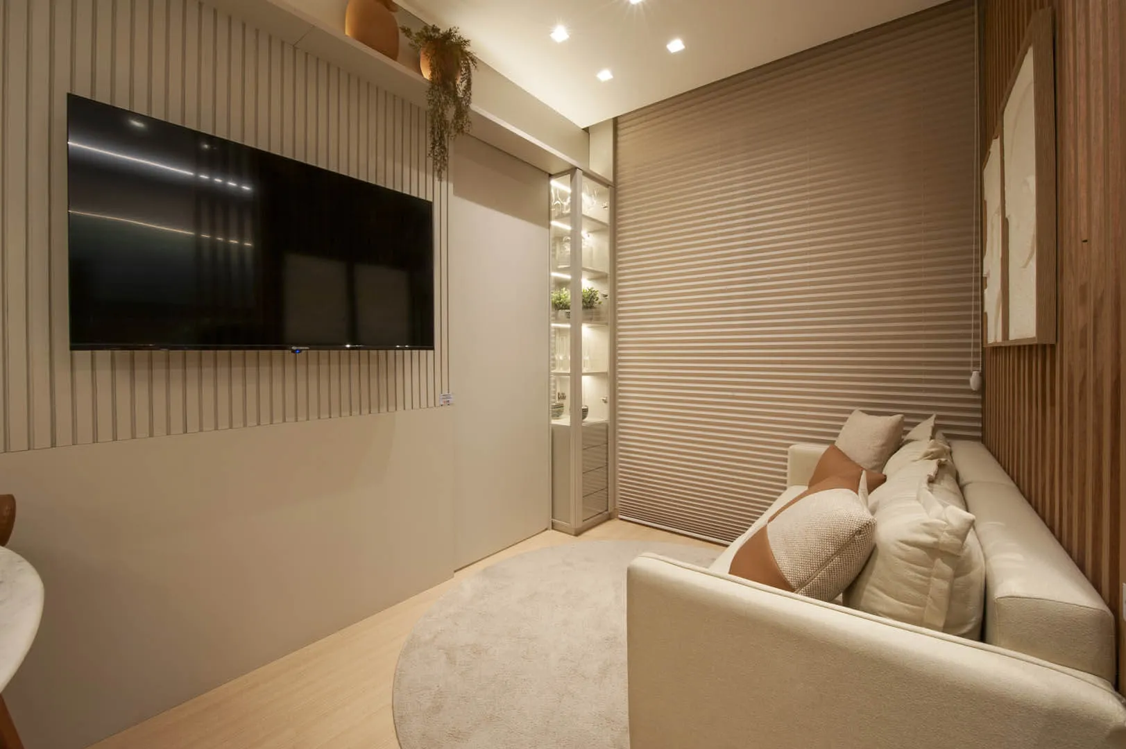 Sala de TV com sofá branco e painel ripado